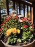 Two resin chickadees on sticks in red mums