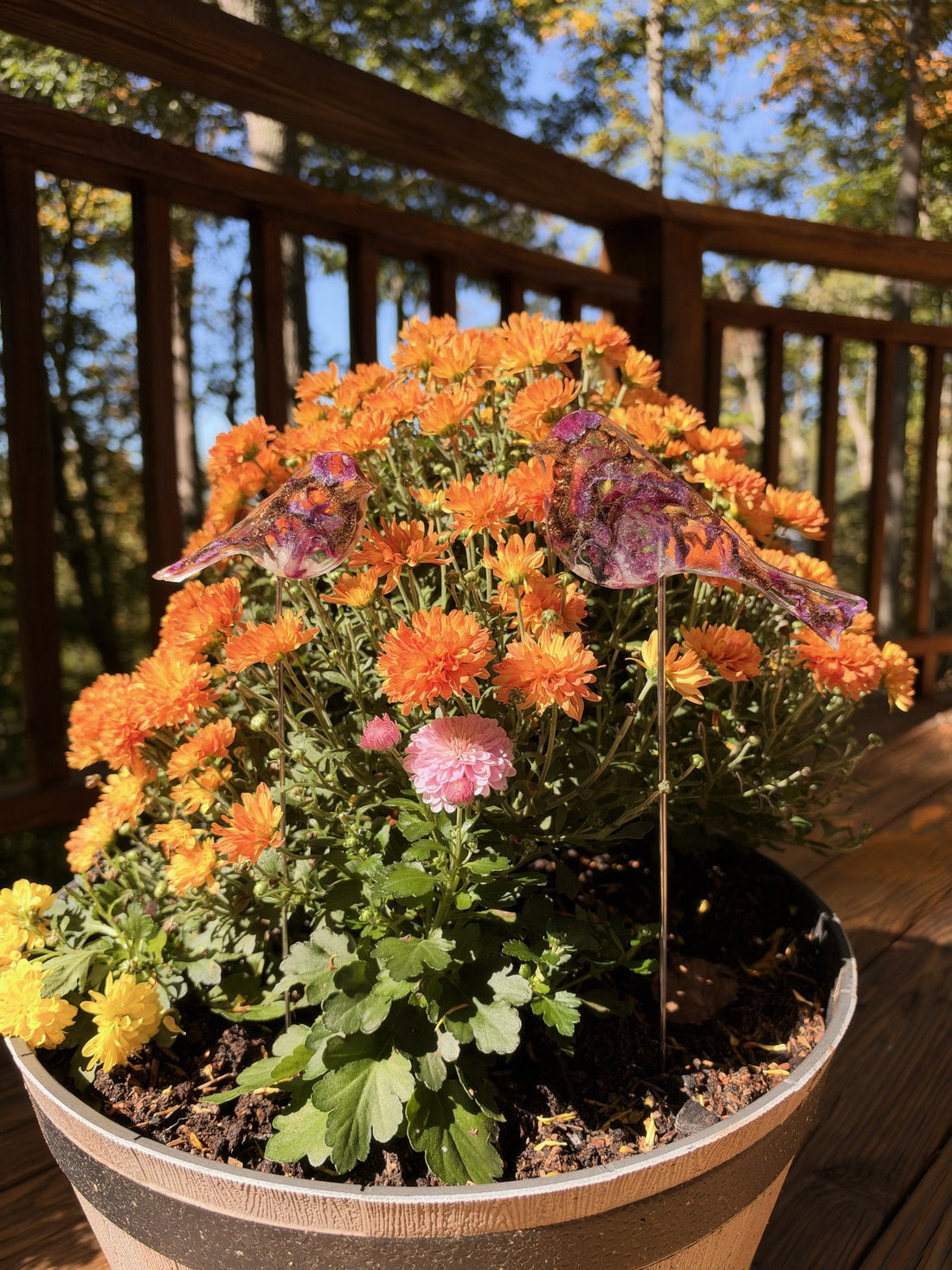 Resin purple finch on a stick in orange mums
